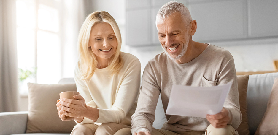 Cheerful couple with financial plans at home