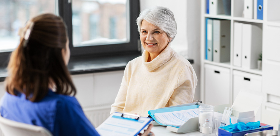 Doctor with clipboard and senior woman at hospital